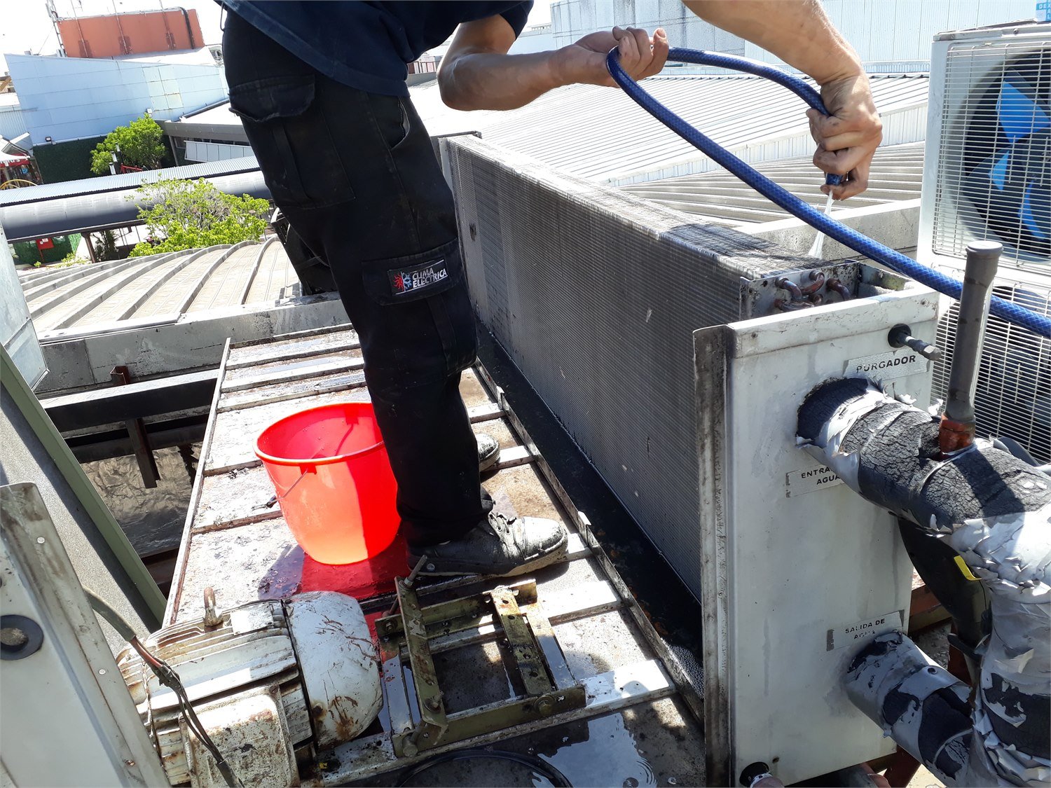 Técnico de Clima Eléctrica realizando limpieza de serpentina